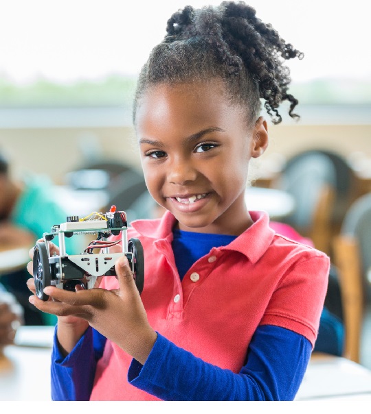 A student proudly holding her finished robot
