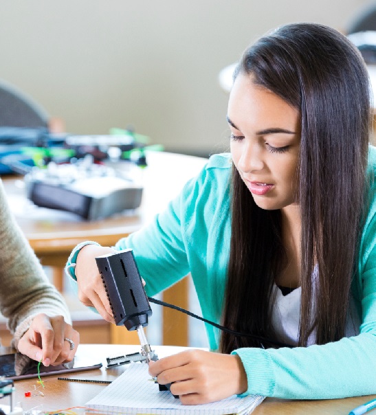 A student examining a BluTiger device during a hands-on engineering lesson